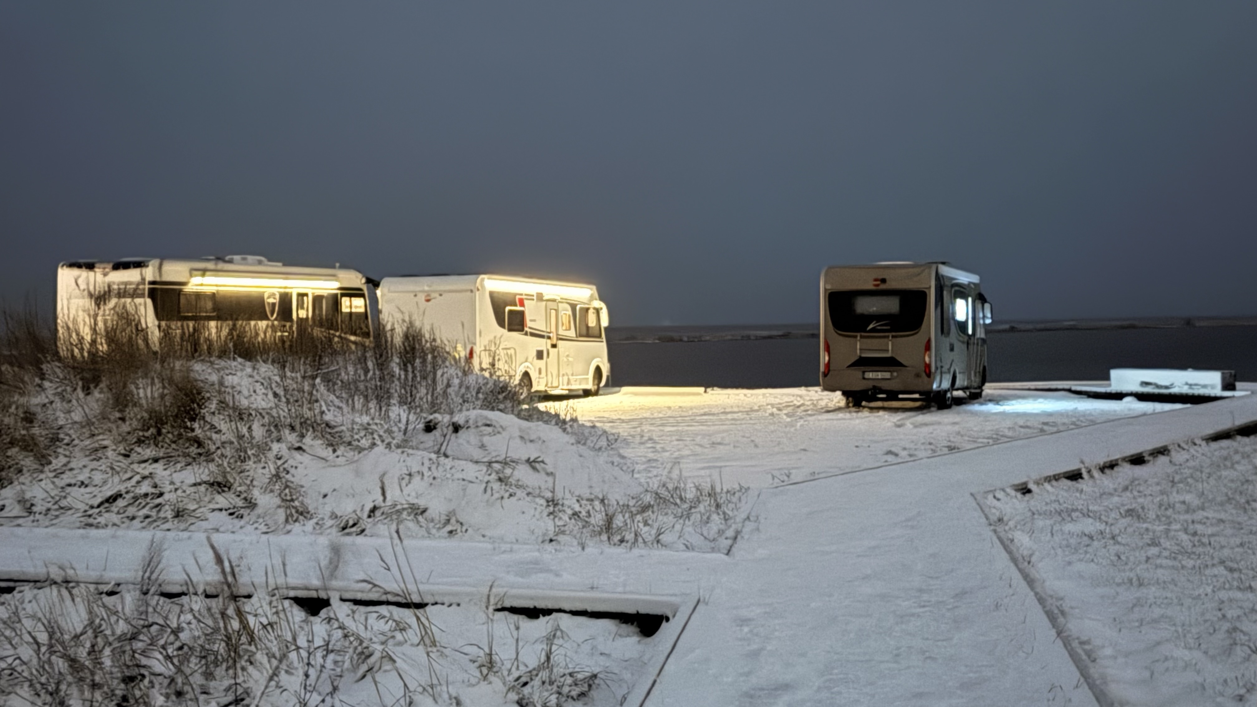 Wohnmobile im Schnee bei Nacht am Stellplatz Hadsund