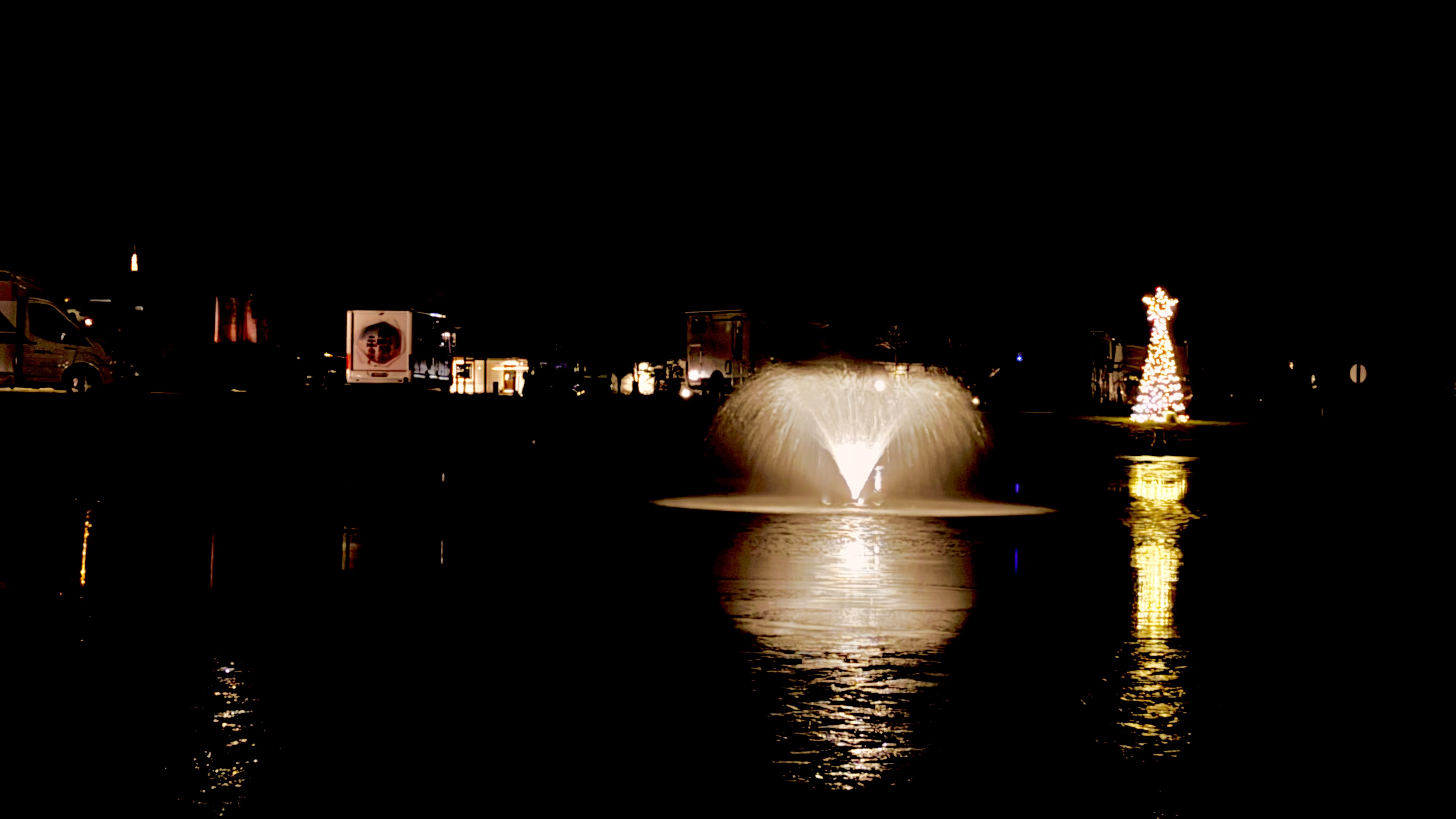 Beleuchteter Brunnen und Weihnachtsbaum auf dem Oasen Stellplatz bei Nacht