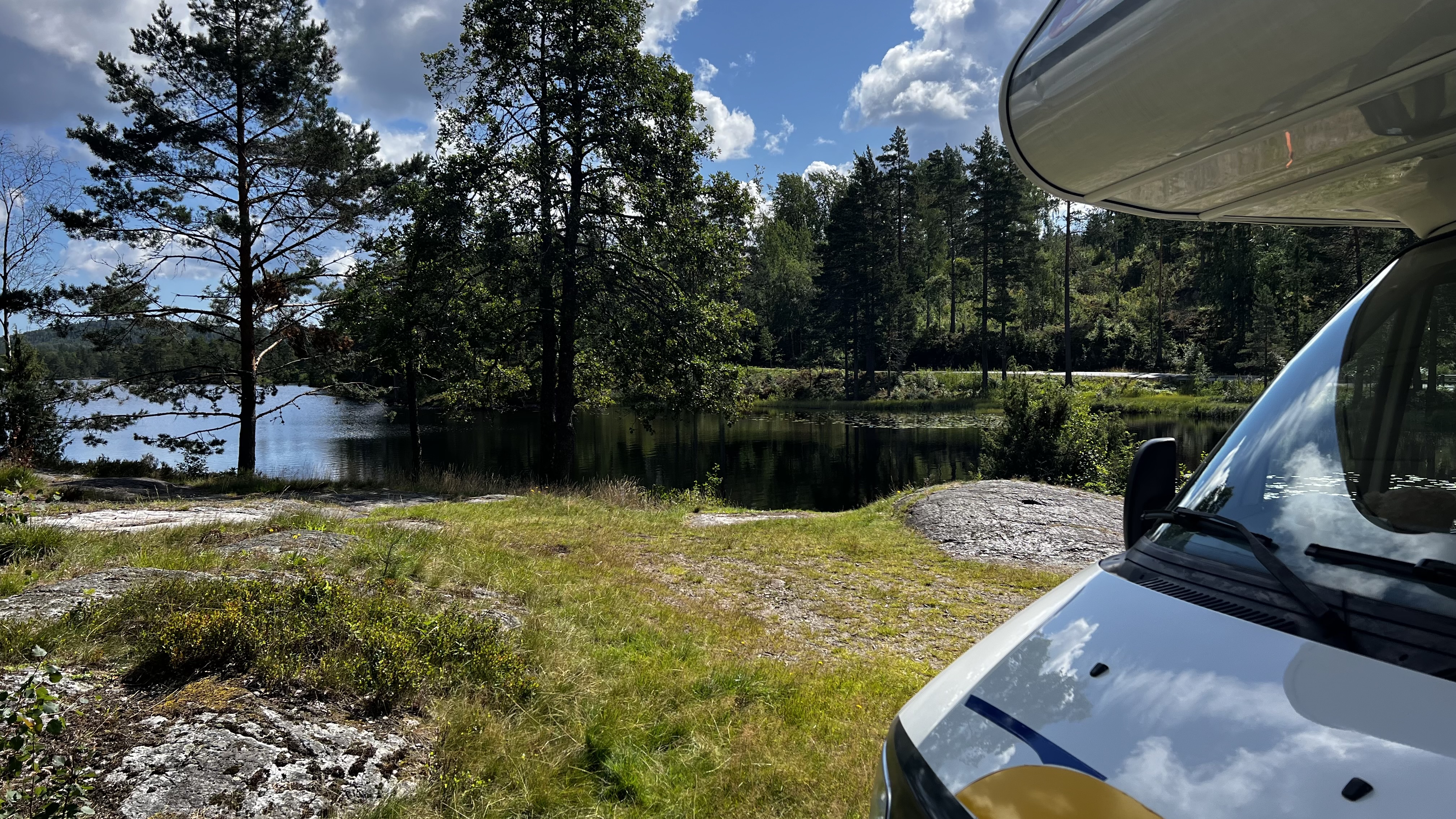Wohnmobil an einem See in Vegårshei in Norwegen, umgeben von Wald